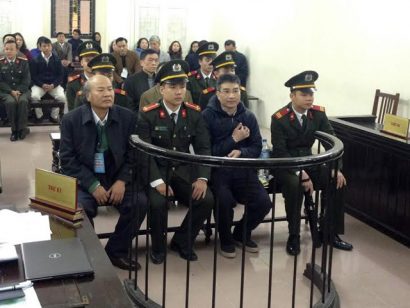  Bị cáo Giang Kim Đạt ngồi giữa hai cán bộ dẫn giải.