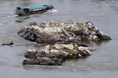  Một chiếc thuyền đi dọc theo các bãi đá ở sông Mekong tại biên giới giữa Lào và Thái Lan ngày 23-4. Ảnh: REUTERS