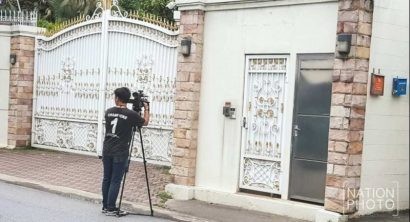 Một phóng viên chờ đợi trước cổng nhà của bà Yingluck. Ảnh: THE NATION.