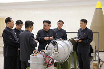 Lãnh đạo Kim Jong Un đứng bên thiết bị được Triều Tiên khẳng định là đầu đạn của tên lửa đạn đạo liên lục địa. Ảnh: Reuters.
