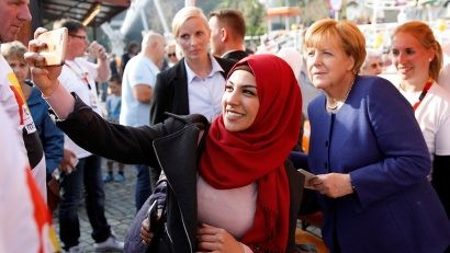  Thủ tướng Merkel chụp ảnh với một phụ nữ Hồi giáo khi đi vận động tranh cử tại TP Stralsund ngày 16-9. Bà không ngại thể hiện tư tưởng cởi mở với các tôn giáo khác và người nhập cư - Ảnh: Reuters