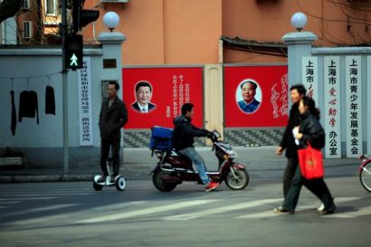  Người dân Trung Quốc trên đường phố với những tấm áp phích in hình Chủ tịch Tập Cận Bình và Chủ tịch Mao Trạch Đông