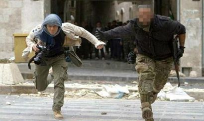  Nữ phóng viên ảnh người Italy Andreja Restek (trái) chạy sang đường trong lửa đạn ở thành phố Aleppo, Syria