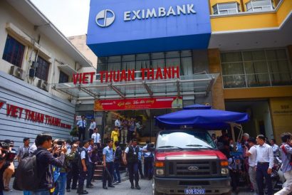 Công an khám xét nơi làm việc và dẫn giải hai nhân viên khách hàng của Eximbank TP.HCM trưa 26-3 - Ảnh: HỮU THUẬN