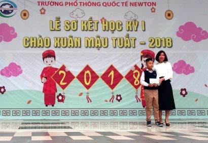 Cô Đặng Huyền Phong – Hiệu trưởng Trường Tiểu học Newton trao phần thưởng cho Dương Đăng Khoa trong lễ chào cờ.