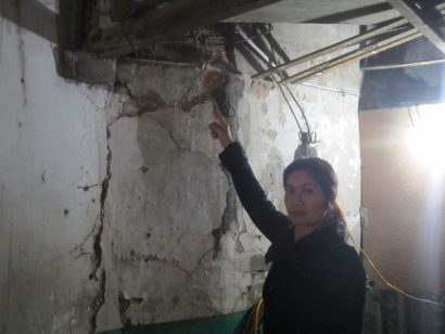 Vợ ông Thủy bên bức tường nứt toác của nhà số 123 Nguyễn Văn Cừ . Ảnh: Ngọ Thi