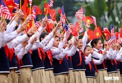  Các học sinh Việt Nam cầm cờ Việt Nam và Mỹ chào đón buổi hội đàm giữa Tổng bí thư, Chủ tịch nước Nguyễn Phú Trọng và Tổng thống Mỹ Donald Trump tại Phủ Chủ tịch - Ảnh: NGUYỄN KHÁNH