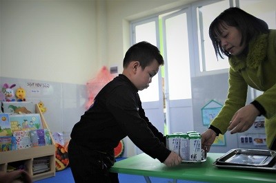 Cô giáo chuẩn bị sữa cho các bé tham gia chương trình Sữa học đường tại một điểm trường ở Hà Nội. 