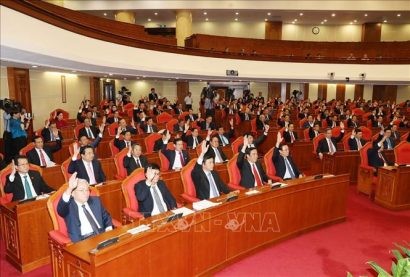 Các đồng chí lãnh đạo Đảng, Nhà nước và các đại biểu biểu quyết thông qua Nghị quyết Hội nghị Trung ương lần thứ mười một. Ảnh: Trí Dũng/TTXVN 