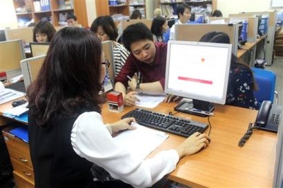 Cán bộ thuế hướng dẫn doanh nghiệp khai hóa đơn điện tử.